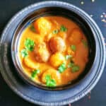 Dum Aloo served in a dinner bowl. This creamy Indian dinner Curry is made with baby potatoes and cooked in the instant pot or stove top.