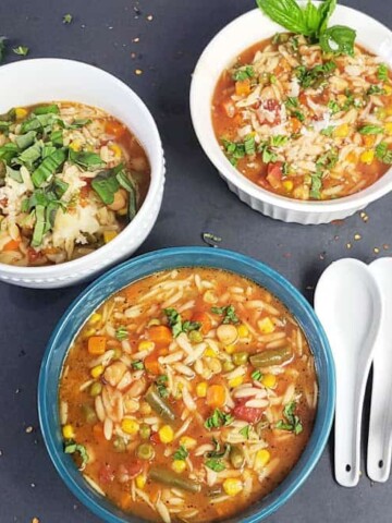 Delicious and easy Vegan Chickpea Orzo Soup garnished and served in soup bowls.