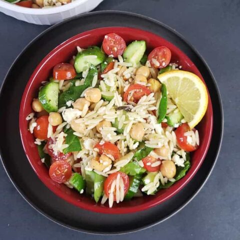 Quick Orzo Pasta Salad with chickpeas and veggies served with freshly made dressing served in a salad bowl.