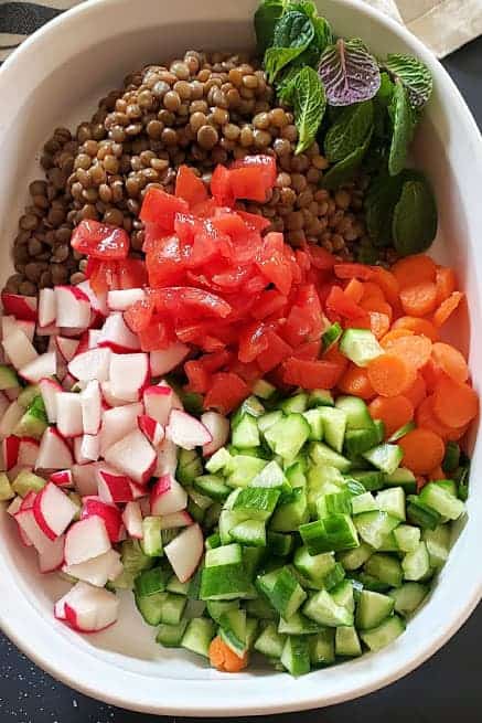 Process step showing all the ingredients gathered together for making a vegan lentil salad.