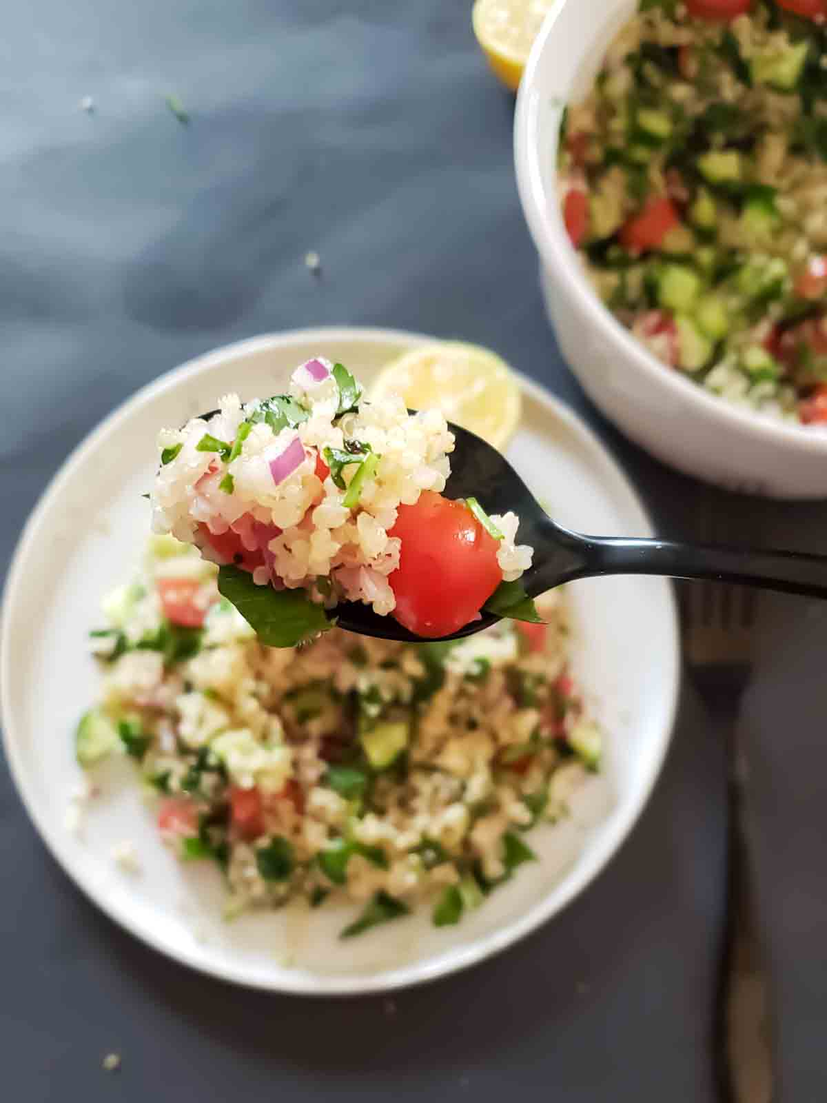 Mediterranean quinoa Salad with quinoa, cucumbers, tomatoes and herbs served for light refreshing lunch.