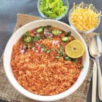 Pinterest image for homemade Mexican Rice served with cheese and lettuce.