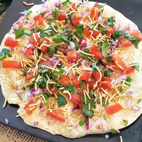 Close up showing beautifully layered vegetarian Indian masala papad.