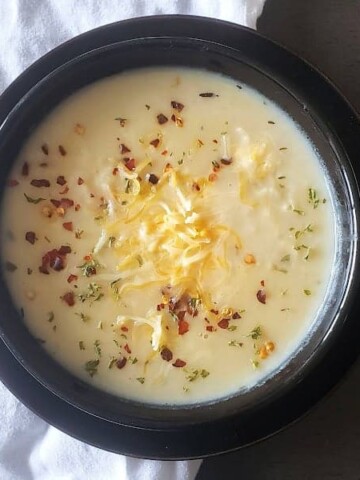 Vegan Creamy Potato Soup served in a black soup bowl. bowl
