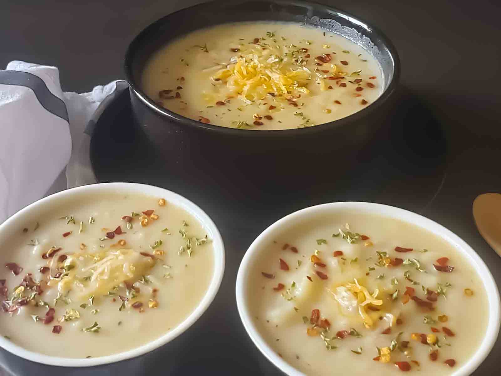 Three bowls filled with potato soup.