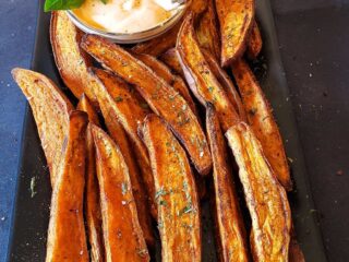 Air fryer sweet potato wedges served with spicy dip.