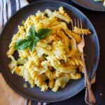 Haluski which is fried cabbage, peas and noodles dish made in Instant Pot and served on black pasta plate with a fork on the side.
