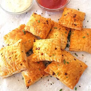 Air fryer golden brown buttery puff pastry squares filled with savory caramelized mushroom filling served as elegant party appetizer.