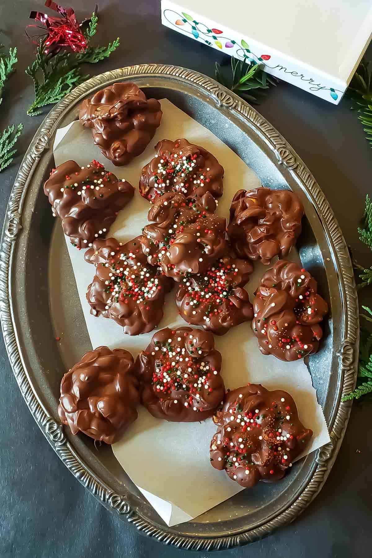 Homemade chocolate peanut clusters on a parchment-lined tray.
