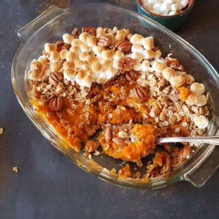 Sweet Potato Casserole with maple pecan granola and marshmallows served for holiday dessert.