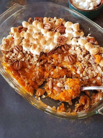 Sweet Potato Casserole with maple pecan granola and marshmallows served for holiday dessert.