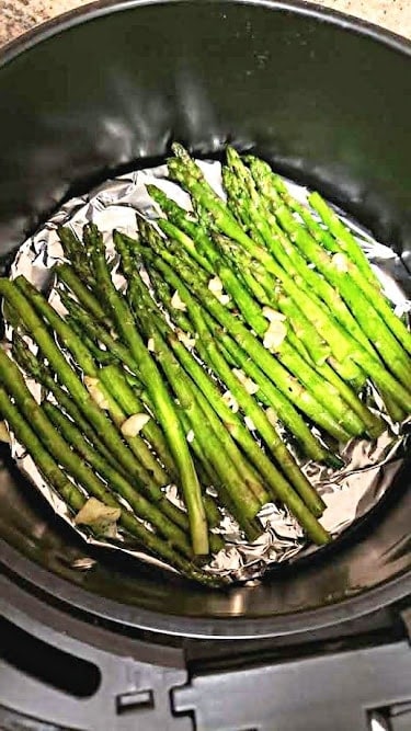 Crisp and tender asparagus made in the air fryer basket.