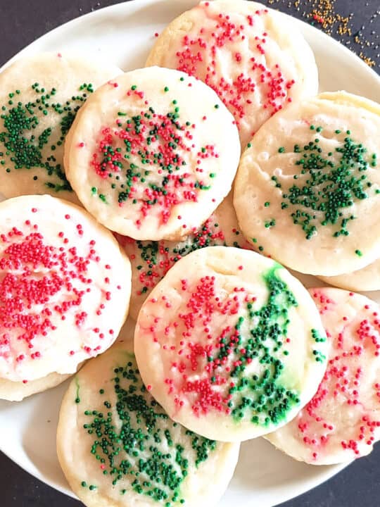Red and green sprinkled sugar cookies arranged on dessert plate.