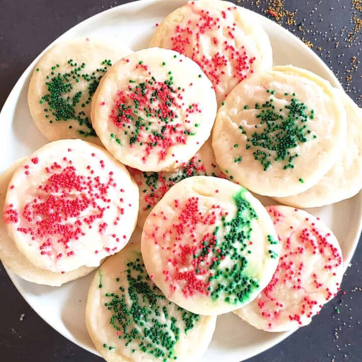 Red and green sprinkled sugar cookies arranged on dessert plate.