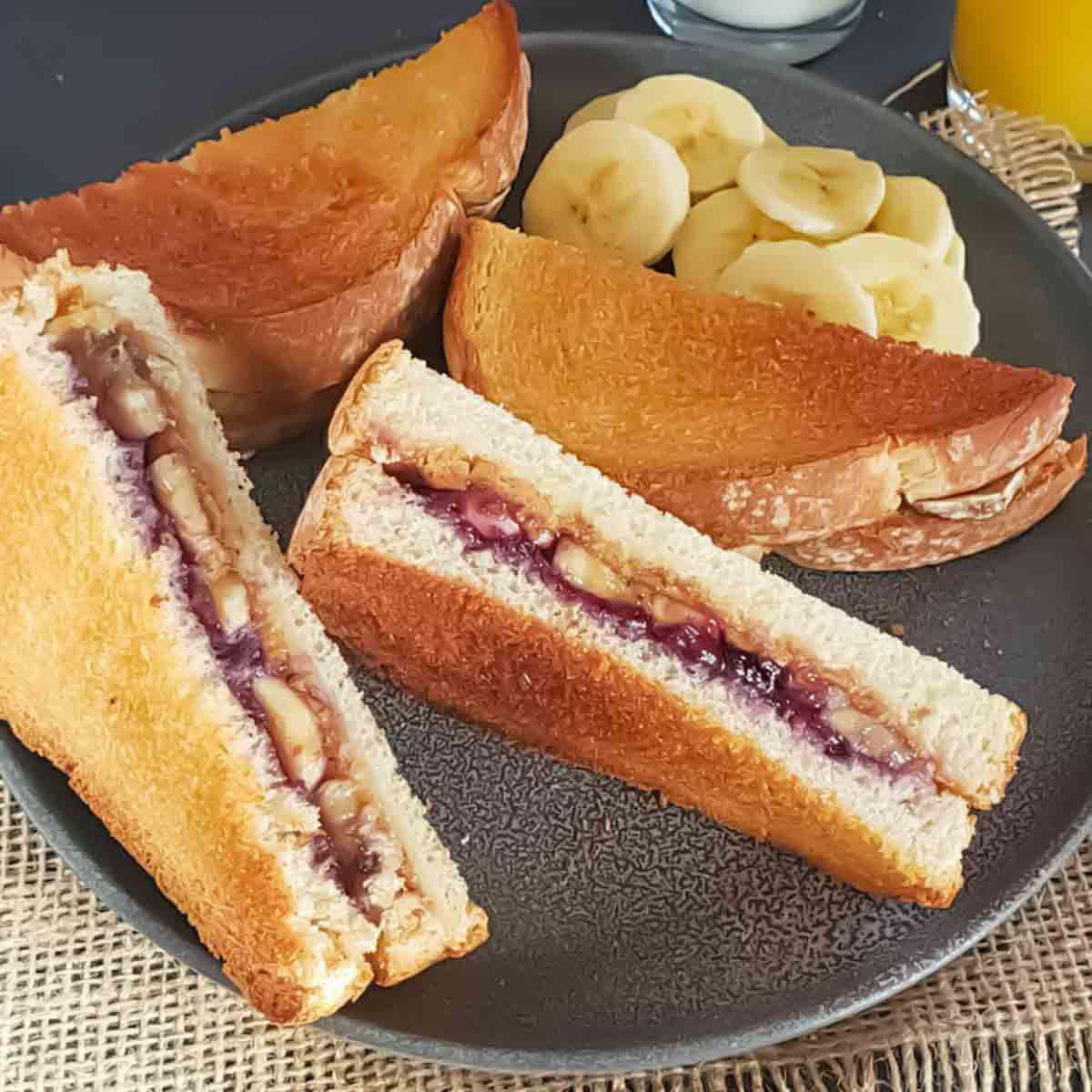 Peanut butter, jelly and banana stuffed toast sandwiches served with milk and orange juice for breakfast or brunch.