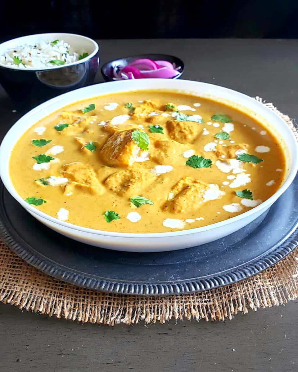 Delicious paneer makhani which is popular Indian curry is served with rice and pickled onions for comfort food dinner.