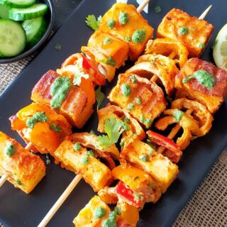 Paneer tikka is Indian barbeque kabab recipe made with marinated cheese, veggies and spices. It is served on skewers for a party appetizer or main meal.