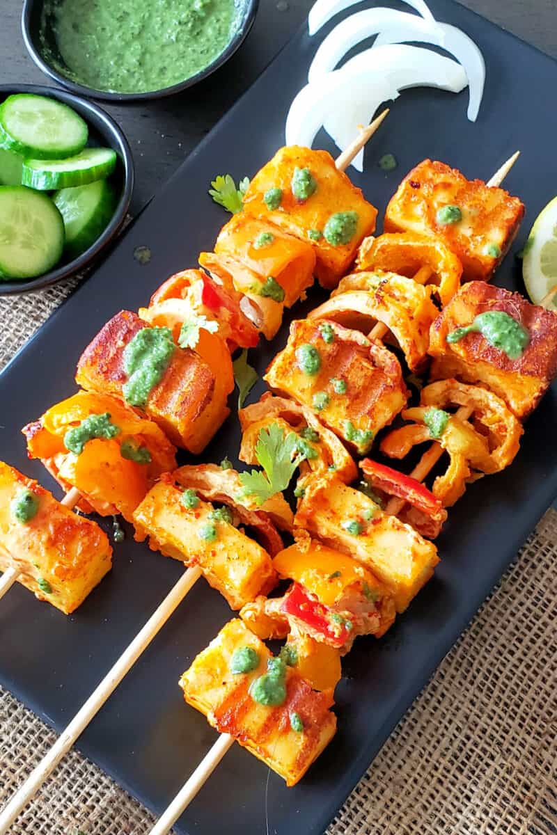Paneer tikka is Indian barbeque kabab recipe made with marinated cheese, veggies and spices. It is served on skewers for a party appetizer or main meal.