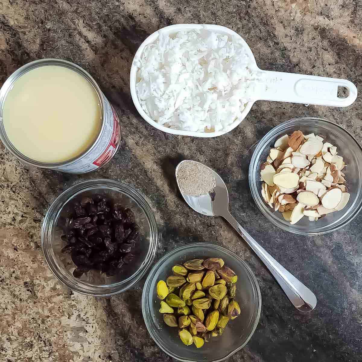 Ingredients used in making Coconut puff pastry dessert with raisins, pistachios, almonds, and cardamom.