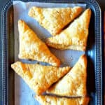 Pinterest image with text overlay for Sweet Coconut pastry made in air fryer. This fusion recipe makes Indian gujiya or karanji in puff pastry.