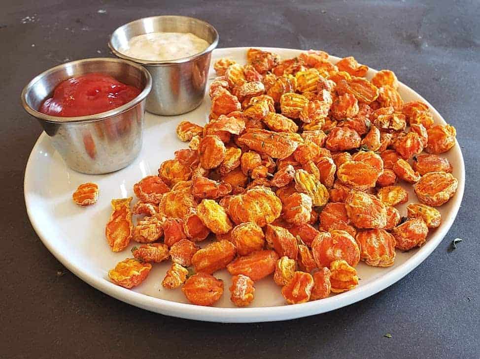 A horizontal image of a serving platter full of roasted carrot chips.