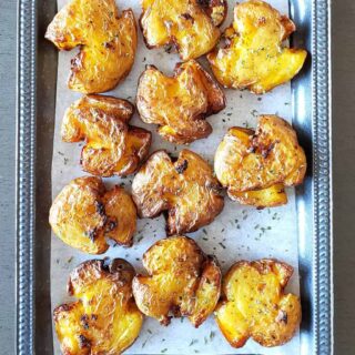 Vegan seasoned smashed potatoes served on the platter.