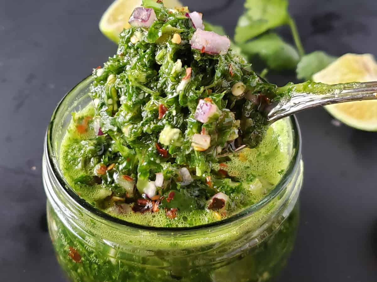 Coarsely chopped herbs and red onion used in condiment called chimichurri.