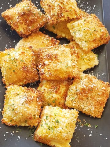 Stack of golden brown and crispy toasted ravioli made in air fryer.