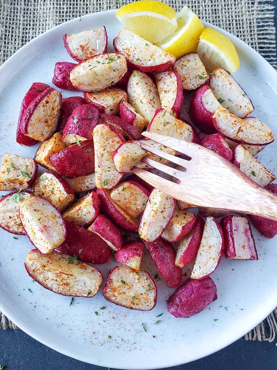 A wooden fork picking up the crispy radish piece.