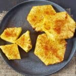 Grilled and seasoned air fryer pineapple slices arranged for serving.