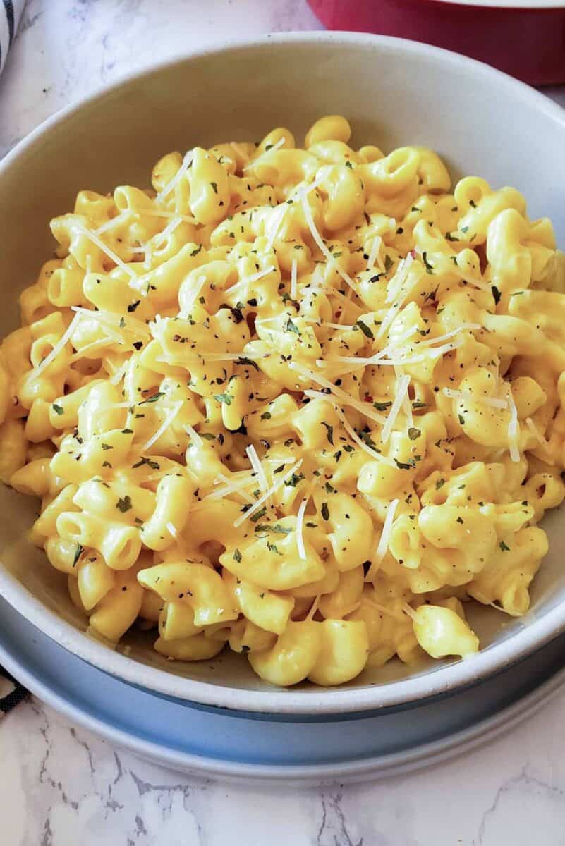 Creamy mac and cheese with garnishes in the bowl.
