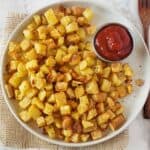 Crispy golden air fryer breakfast potatoes served with ketchup for hearty breakfast.