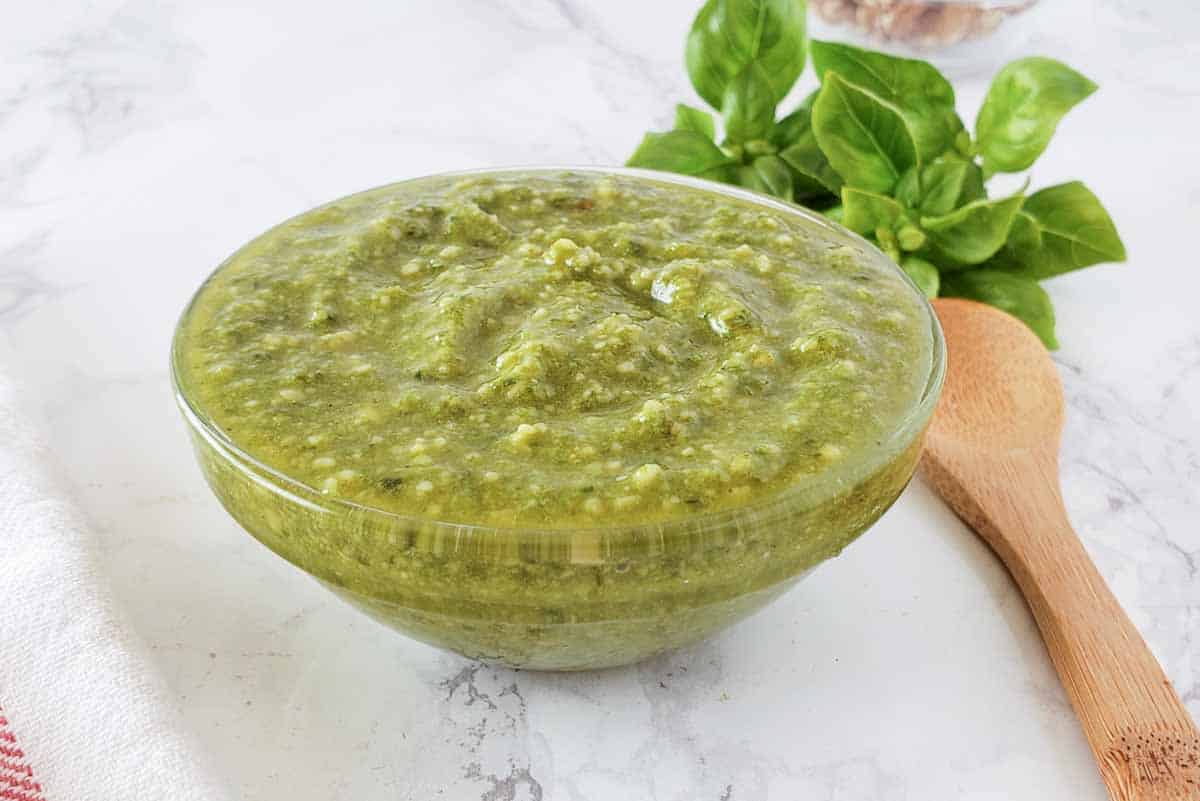 A glass bowl filled with pesto sauce.