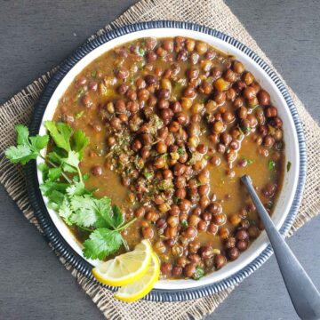 Kala Chana curry with cilantro and lemon in a bowl.