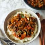 Mushroom Stew with vegetables and seasoning served over mashed potatoes for comforting vegan and gluten free dinner.