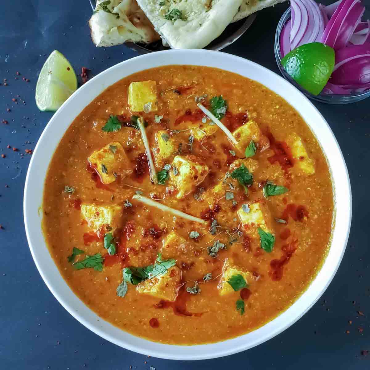 Achari paneer which is Indian dinner curry , made with soft cottage cheese cooked in pickle spice mix and onion tomato gravy, served for dinner.