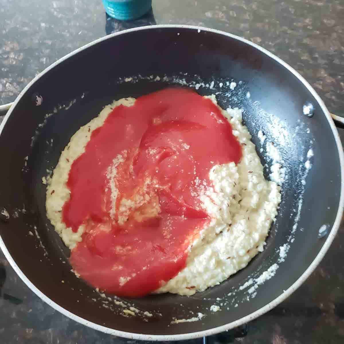 Process step two- adding tomato puree to the mix.