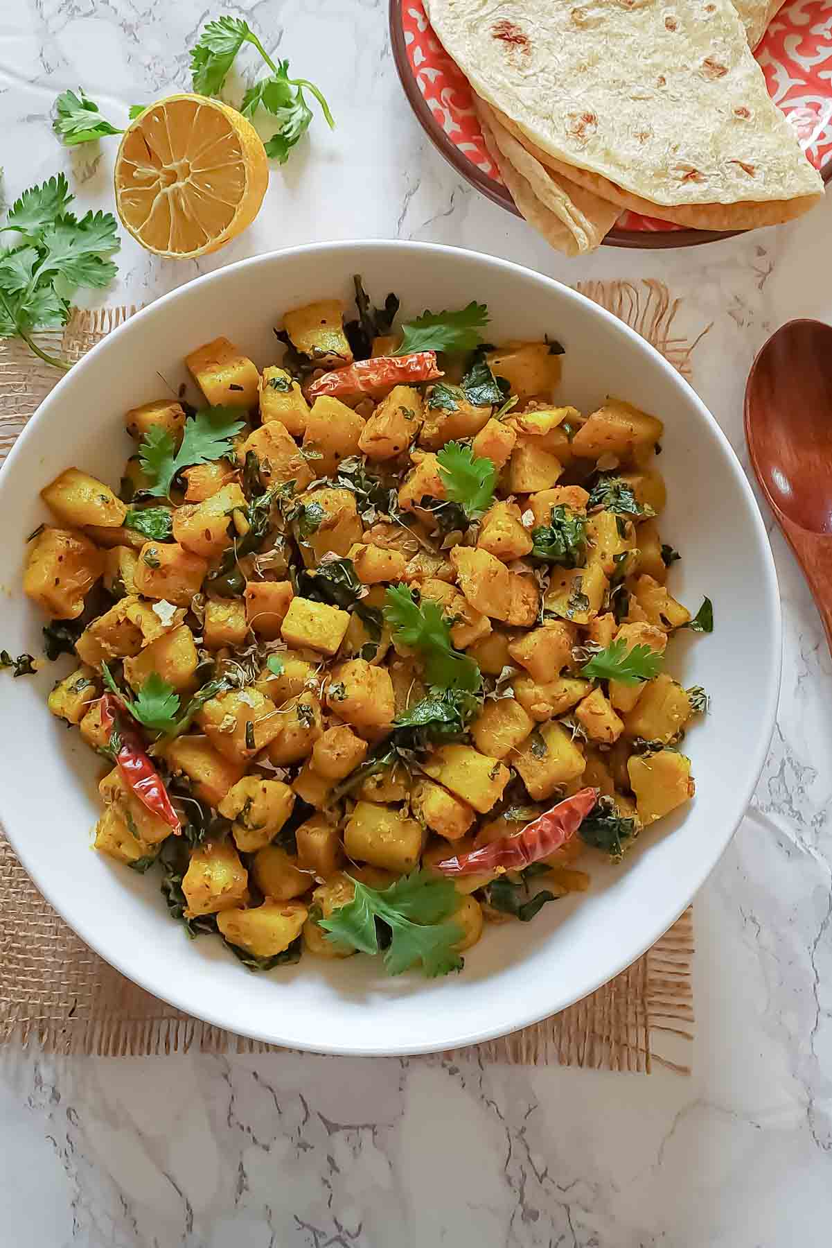 Authentic Aloo Palak recipe served with garnishes 