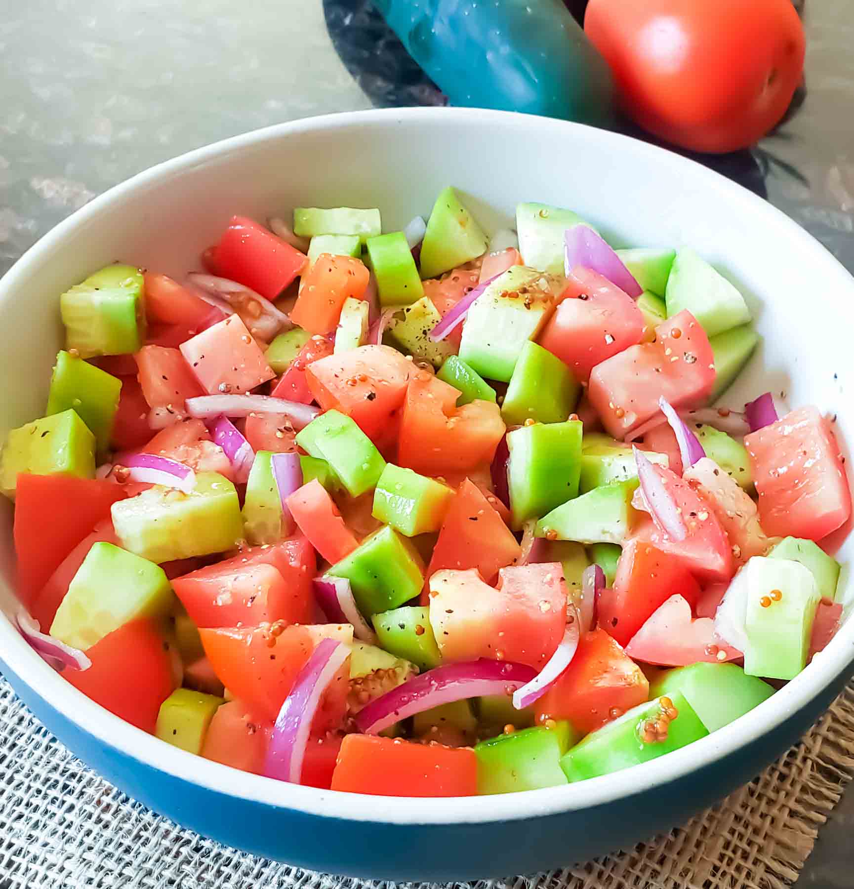 Bite sized cucumber, tomatoes and red onion with herbs and balsamic served as a salad. 