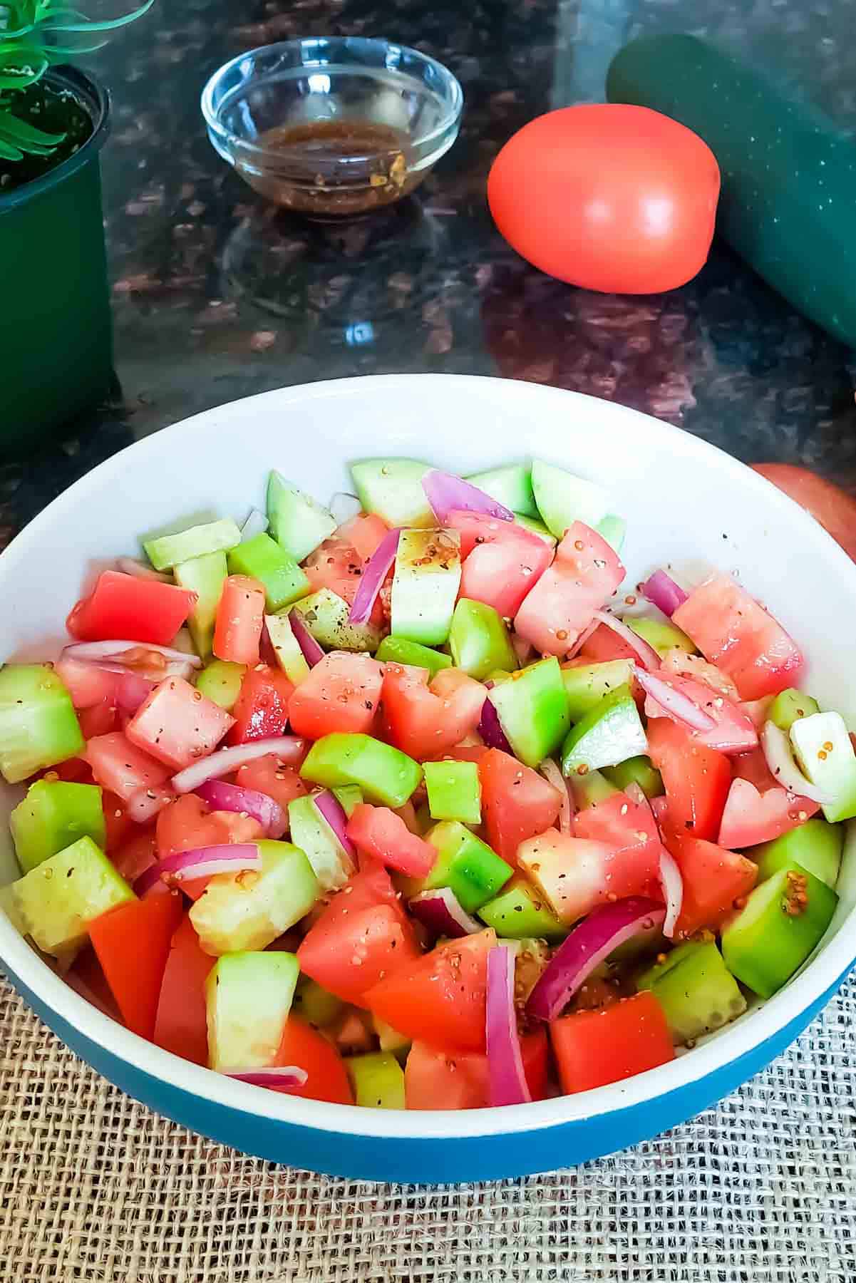 Process shot image of Meditararian cucumber tomato salad with maple balsamic vinegar dressing.