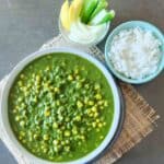 Vibrant corn palak Curry with garnishes in a bowl.