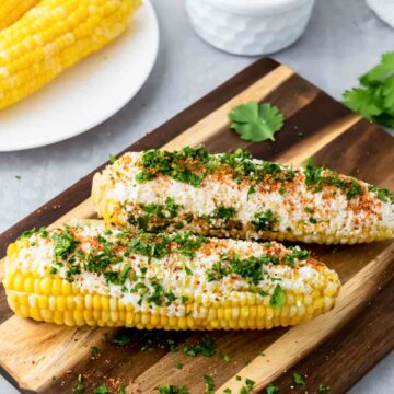 An overhead shot of street corn on the cobs served with toppings.