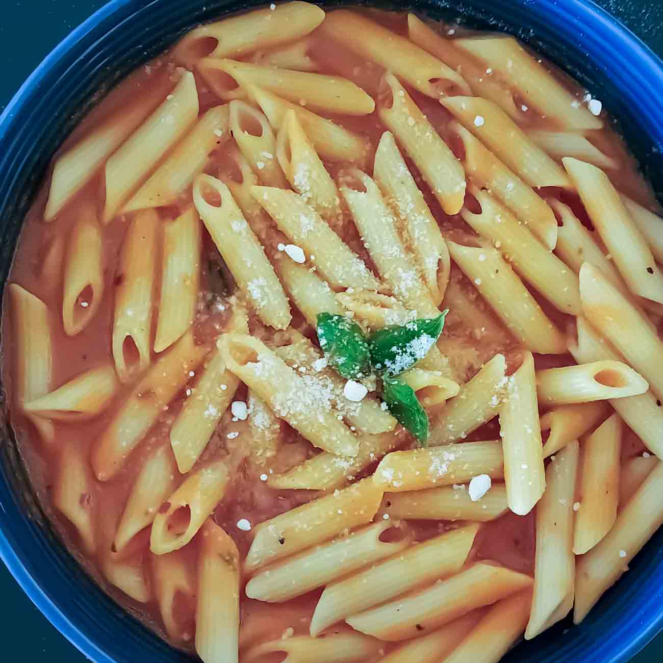 Roasted Red pepper Penne Pasta served with garnishes.