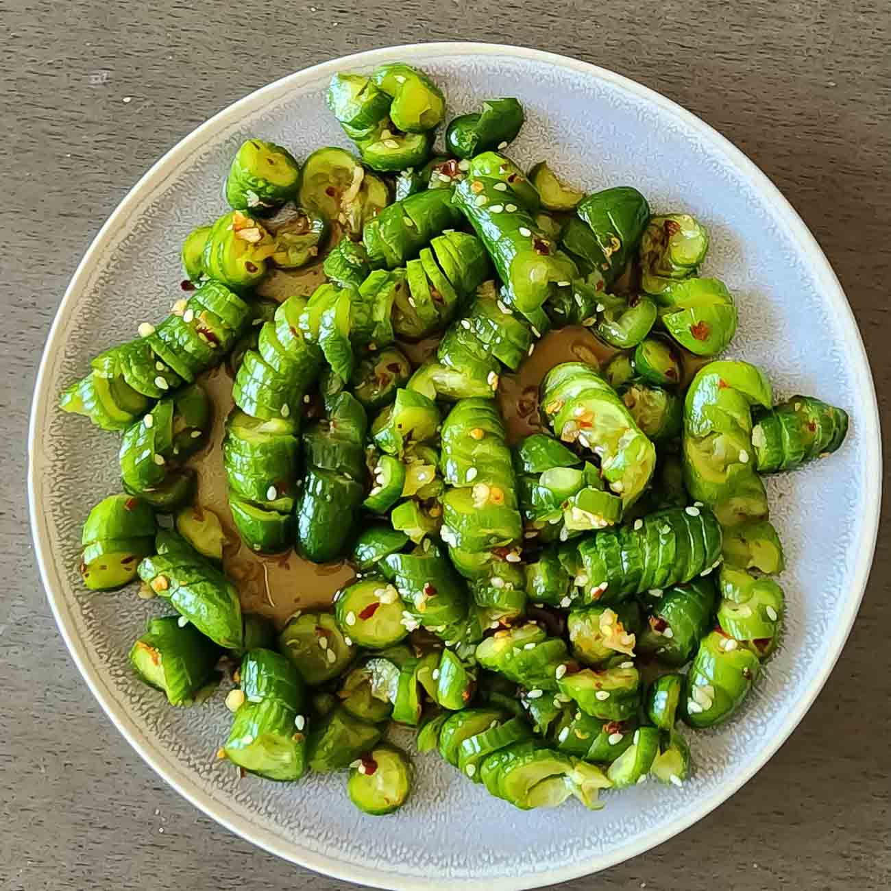 Asian Cucumber Salad with spicy tangy dressing and sesame seed garnishes served.