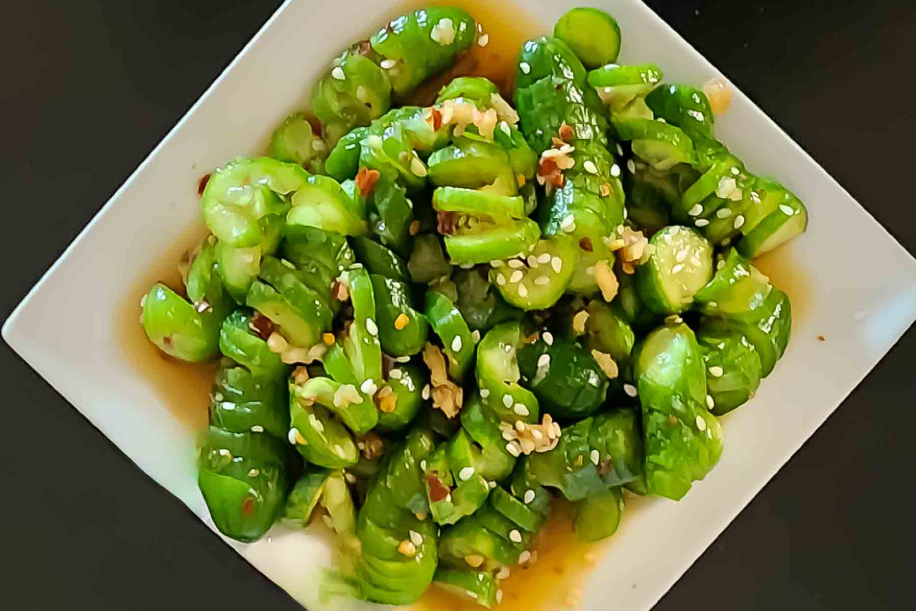 Prepared spicy cucumber salad served with the garnishes.