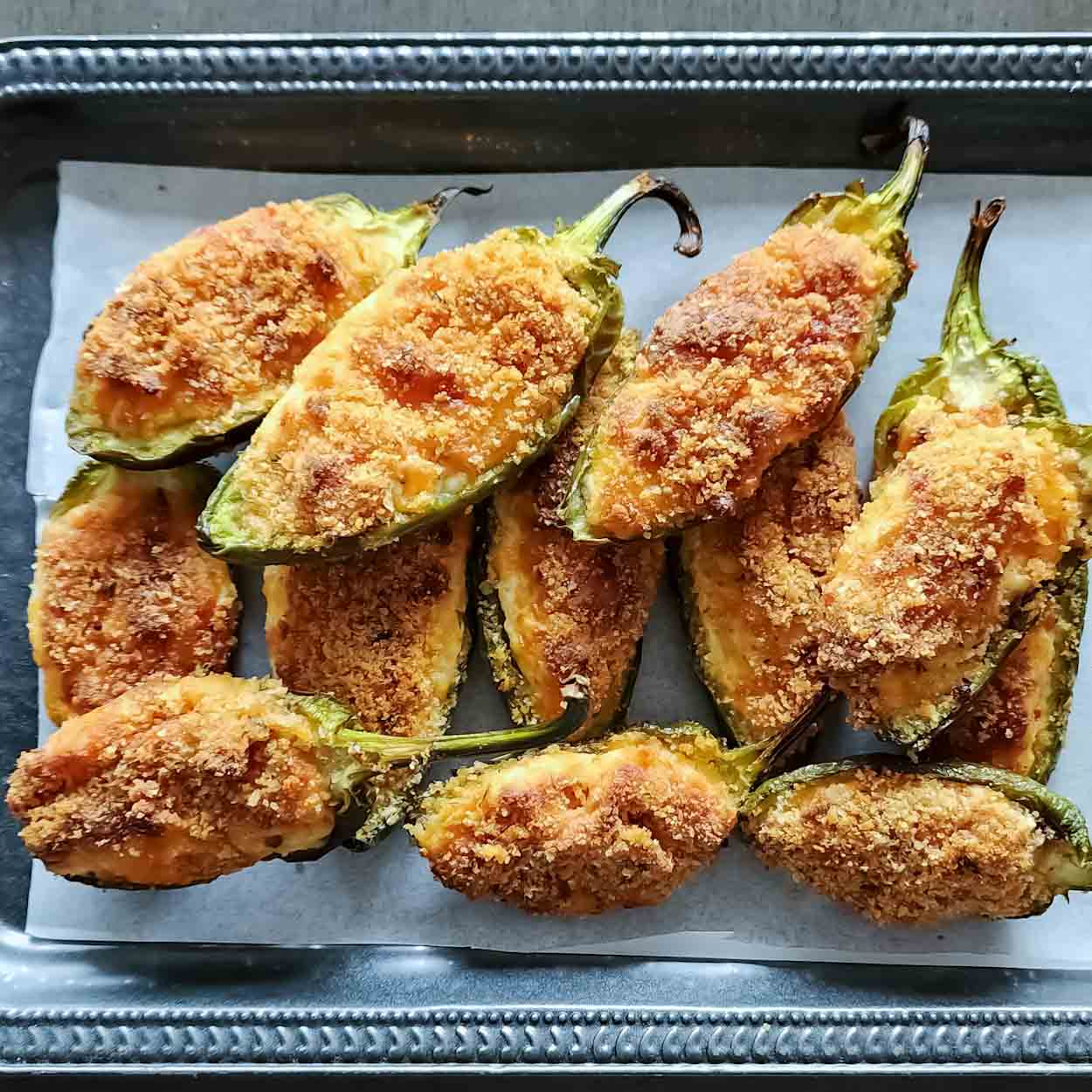 Jalapeno poppers with cream cheese baked to golden brown and served for an appetizer.