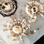 Chocolate spider web pretzels with sprinkles for Halloween treat.