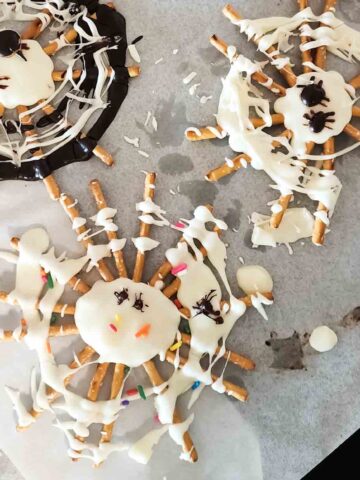 Chocolate spider web pretzels with sprinkles for Halloween treat.