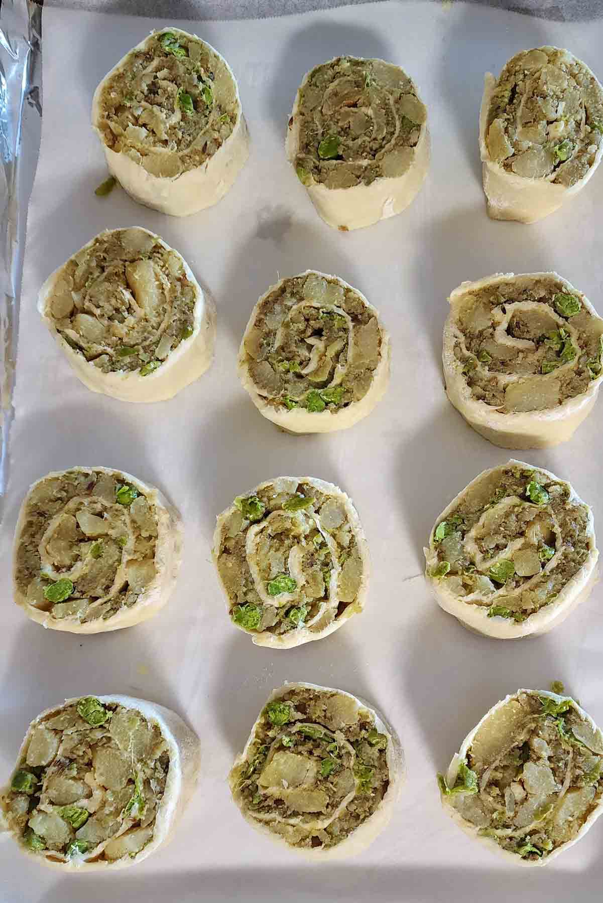 Prepared puff pastry samosa pinwheels ready for oven baking.