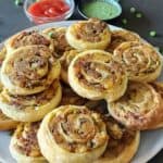 Buttery flaky Samosa Puff Pastry pinwheels served with ketchup and mint chutney.